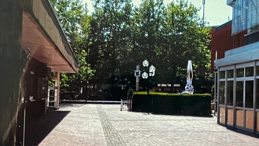 Spätere Platzsituation mit Metall-Uhr und veränderter beziehungsweise verschwundener Außengastronomie